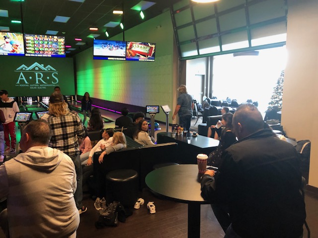 A group of people sitting in a bowling alley.