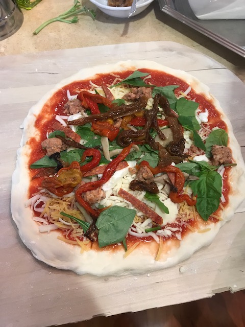 A pizza is being made on a wooden cutting board, ensuring it is suitable for SEO purposes.