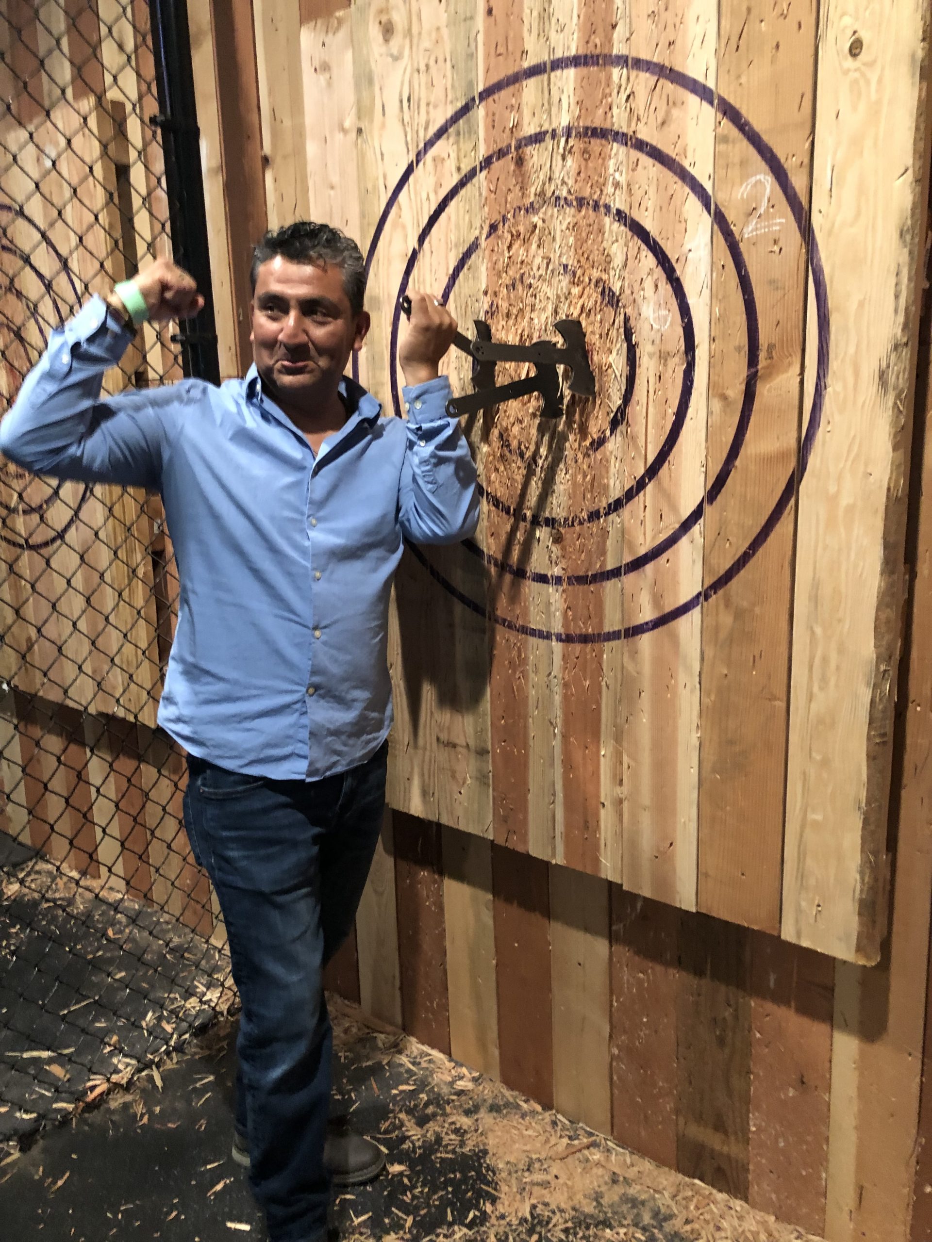 A man posing in front of a wooden target.