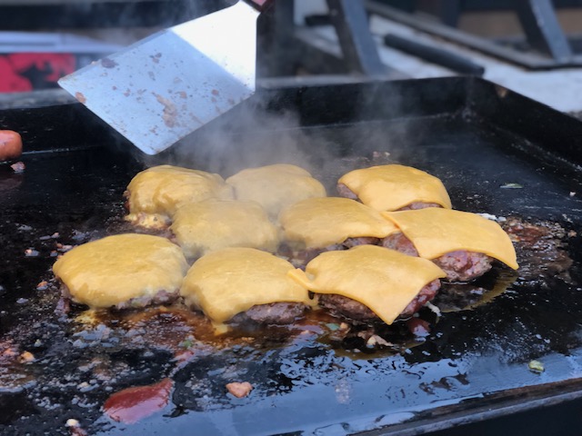Burgers being grilled on a grill.