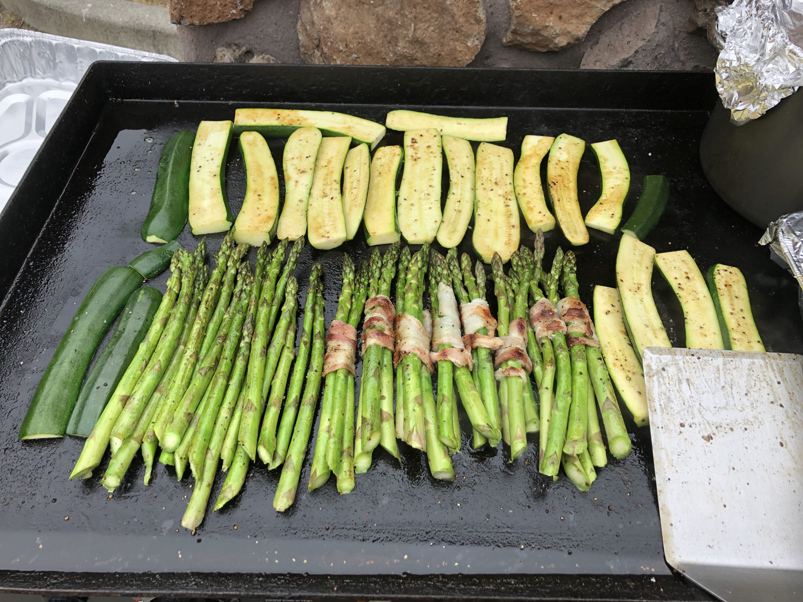 A grill with asparagus and zucchini on it.